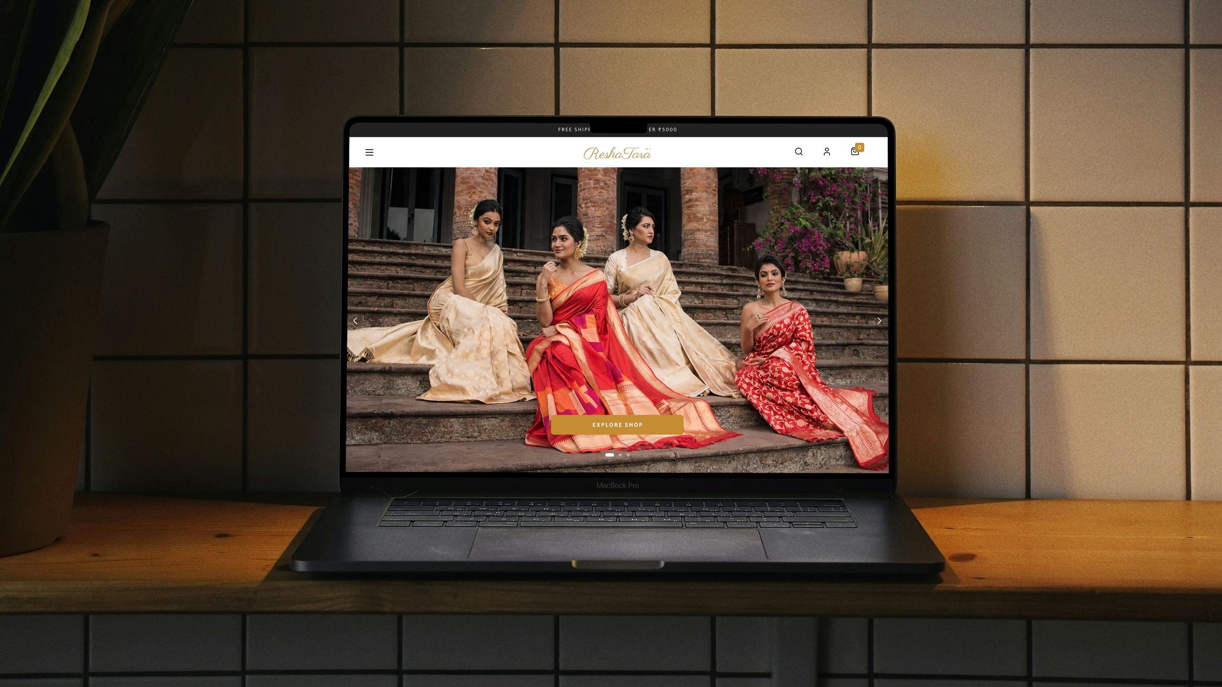 The Reshatara landing page on a laptop: four women in Banarasi silk sarees on old stone steps